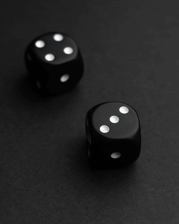 Close-up of two black dice on a dark background, ideal for gambling themes.