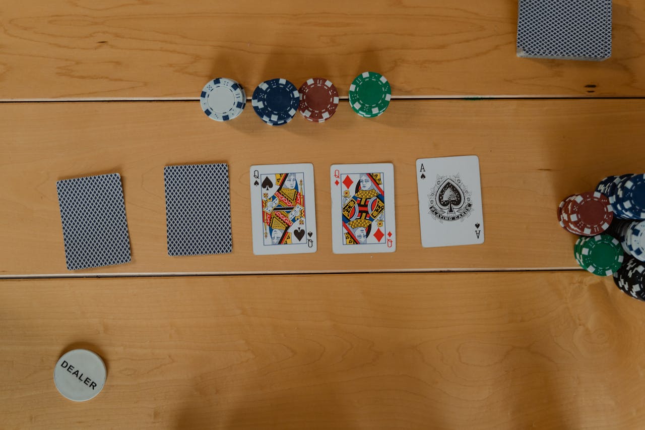 A poker game setup showing cards and chips on a wooden table, ready to play.